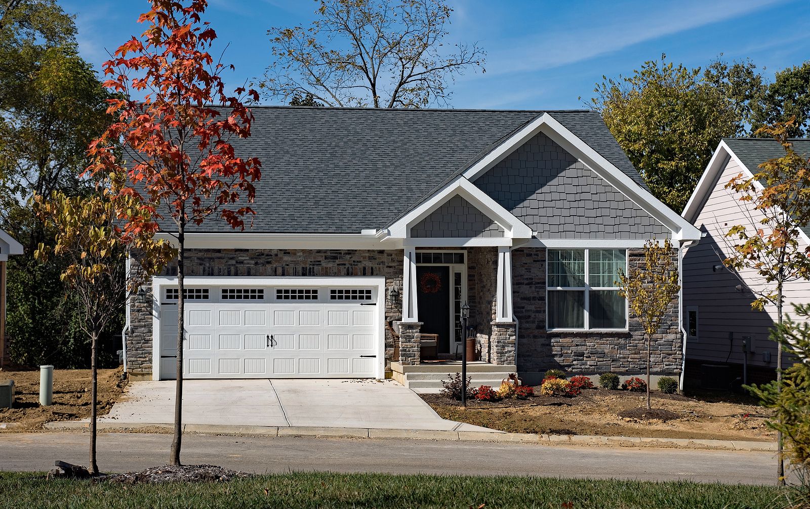 Newly-Built-Upscale-Stone-Home-in-Fall-with-White-Garage-Door